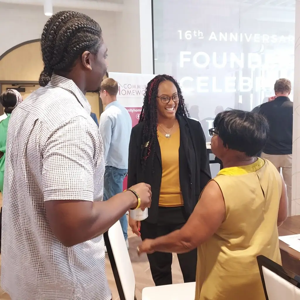 Three people talking at a Community Homeworks Kalamazoo anniversary celebration.
