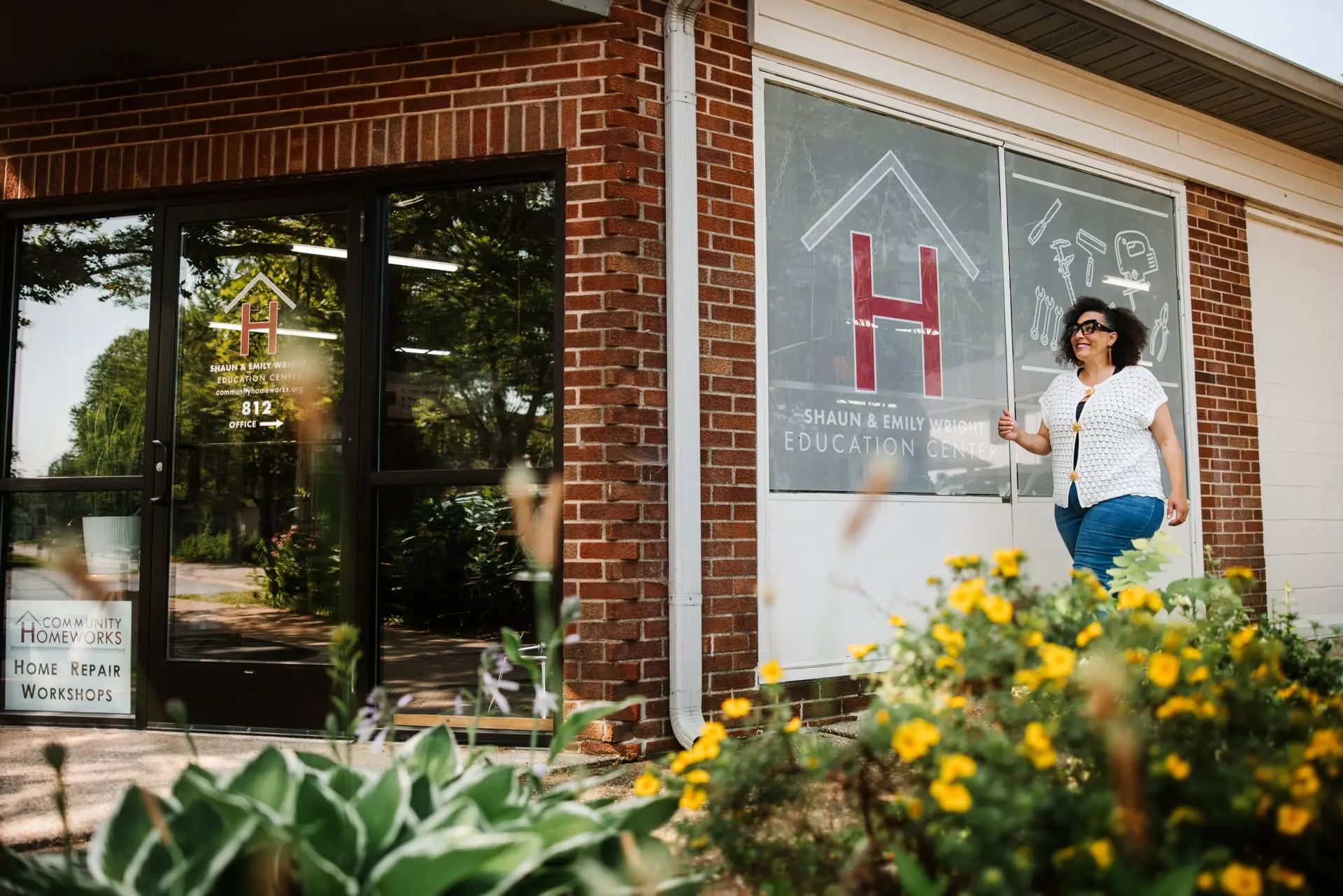 Woman walking in front of Community Homeworks building.