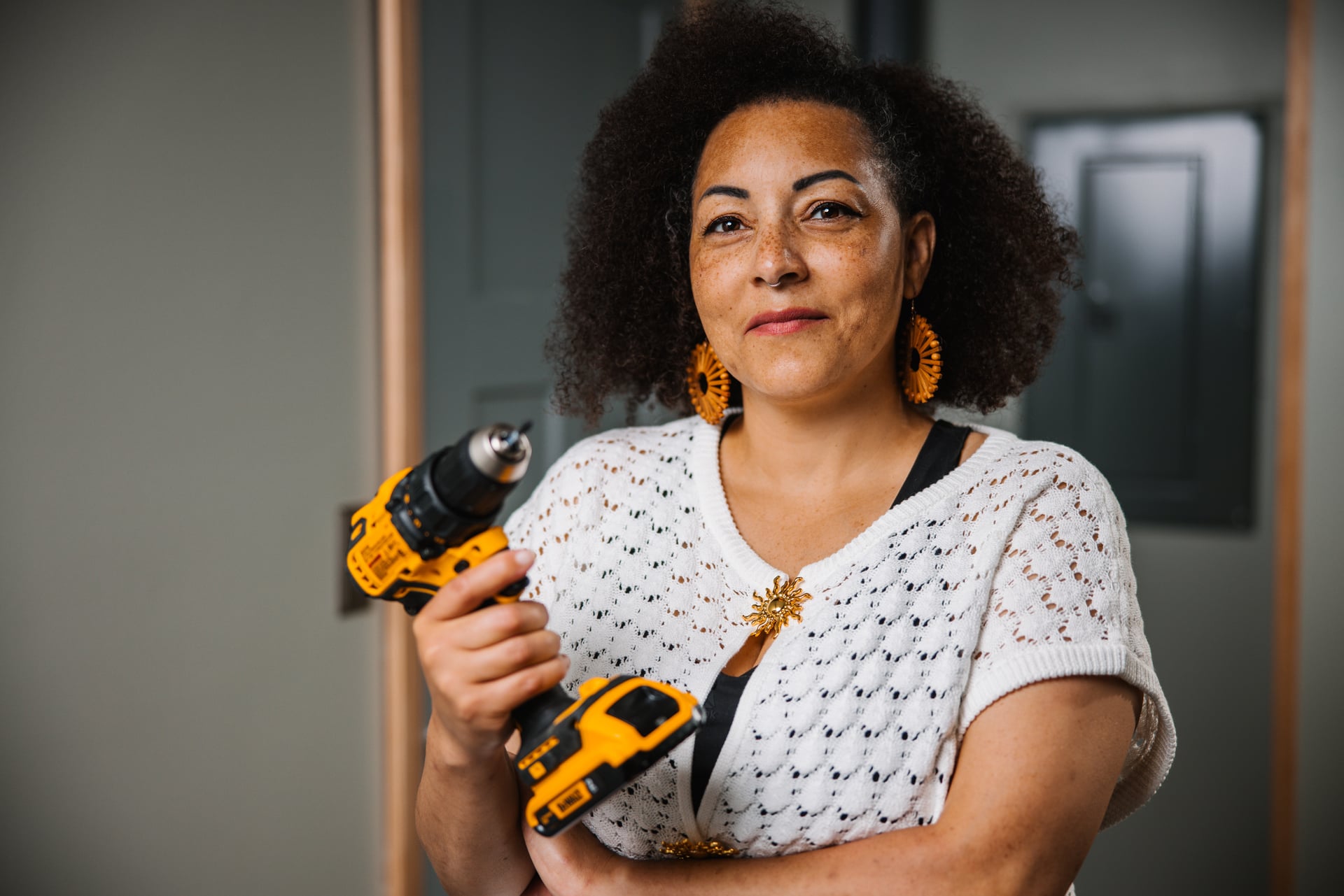 Woman holding a power tool.